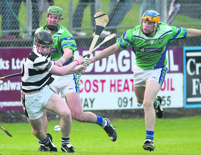 Turloughmore's Michael Morris is challenged by John Shiel and Paul Killeen of Tynagh/Abbey-Duniry during the clubs' county championship clash at Kenny Park on Friday evening. Photos: Joe O'Shaughnessy.