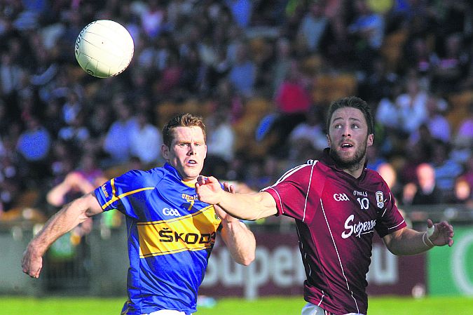 Galway's Michael Lundy and Tipperary's Ger Mulhair follow the flight of the ball during Saturday evening's All-Ireland football qualifier in Tullamore. Photo: Enda Noone.