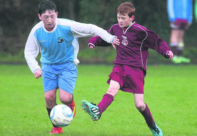 Mervue United's Jamie McIntyre and Athenry's Niall Dooley tussling for possession during the clubs' U-14 Cup game in Mervue on Saturday.