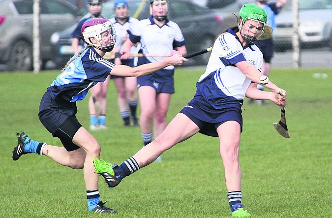 Kinvara's Leanne Helebert gets in her strike despite the best efforts of St. Mary's Eimear McGuigan in the senior A colleges camogie semi-final in Kinvara on Saturday. Photos: William O'Reilly.