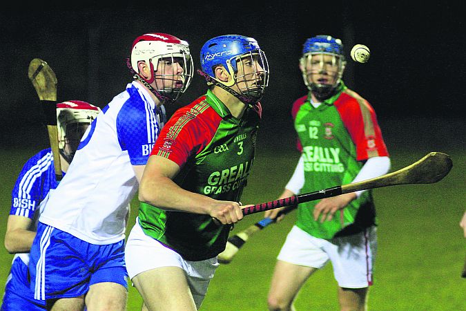 Calasanctius College's Ronan Walsh looks to clear his lines as St Joseph's Diarmuid Byrne closes in.