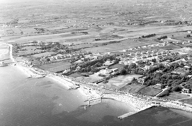 An aerial view of Salthill in the late 1960s. In the background is the expanse of Galway Golf Club, while further back in Knocknacarra most of the land is now covered in housing. Judging by the numbers on the beach and the cars lining the promenade, the photo seems to have been taken at the height of Summer.