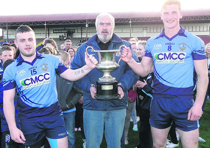 Chairman of the North Board, JP Kelly, presents the cup to Headford's joint captains, Alan Meeneghan and Michael Day.