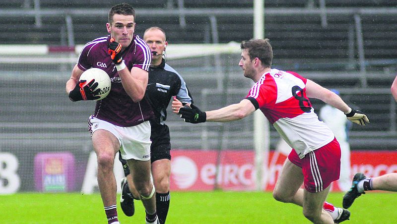 Galway midfielder Fiontán Ó Curraoin braces himself for the challenge of Derry's Niall Holly during the All-Ireland football qualifier at Pearse Stadium on Saturday evening. Photo: Enda Noone.