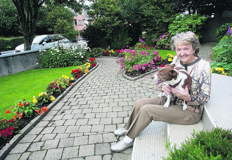 Mary Bennett and her dog Max, in her garden at Dr Mannix Road, winner of the Salthill area of the Tidy Towns.