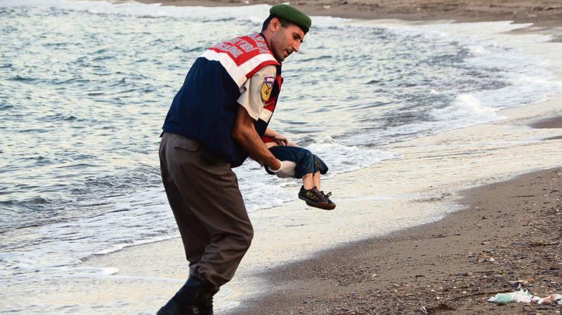 Turning point...the body of little Aylan Kurdi carried from where he was washed up on a Turkish shore.