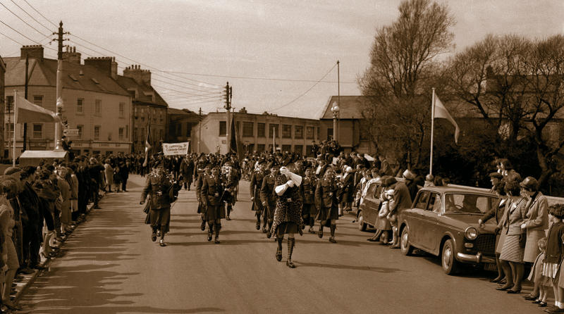 The army band leads the 1916 50th anniversary parade over O'Brien's Bridge in Galway in Easter 1966. In the background, stands the old Galway Foundry on a site occupied today by Galway Garda Station, Mill Street. Photo: Stan Shields.