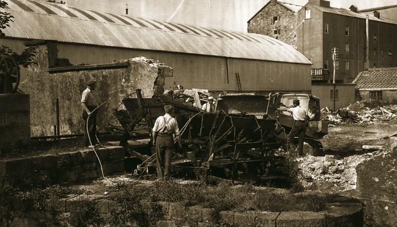 A mill wheel being dismantled and a site being cleared for the building of a new St Joseph's College (The Bish) Secondary School at Nun's Isalnd , Galway in June 1967. The site abuts onto one of Galway's old waterways.