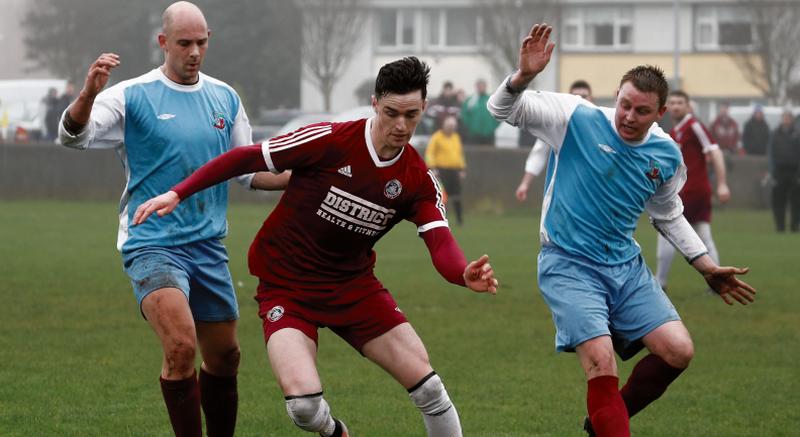 Athenry's Colm O'Donovan comes away with the ball despite the attentions of Mervue's Kevin Fitzpatrick and Kevin McHugh during the clubs' Premier League clash at Fahy's Field on Sunday morning. EIREFOTO