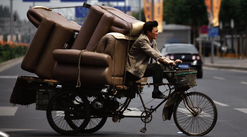 The wheel and the bike are still kings of the streets in Beijing despite the proliferation of big motors as well. Here, a Beijing native 'brings home' his three piece suite of furniture on his power assisted bike/trailer.