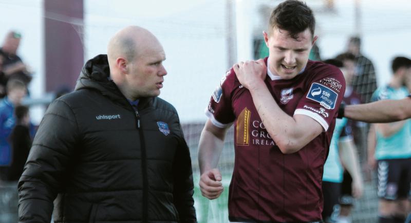 Galway United's Padraic Cunningham having received treatment from physio, Kevin Darcy, after landing heavily on his shoulder against Derry City on Monday night. Photo: Joe O'Shaughnessy.