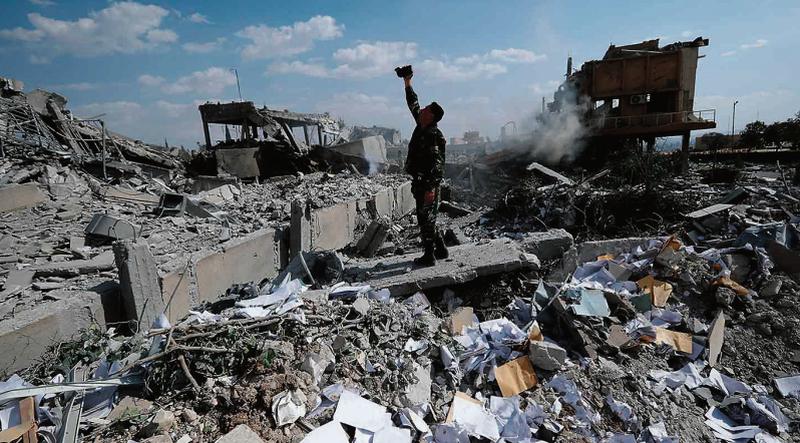 A Syrian soldier surveys the ruins of a scientific research facility after last weekend's military strikes.