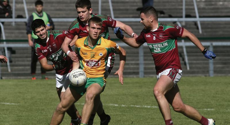 St. James' Cathal O'Regan, Aaron Connolly and Rob Wynne surround Corofin's Darragh Silke during Sunday's senior football championshiop tie at Pearse Stadium.