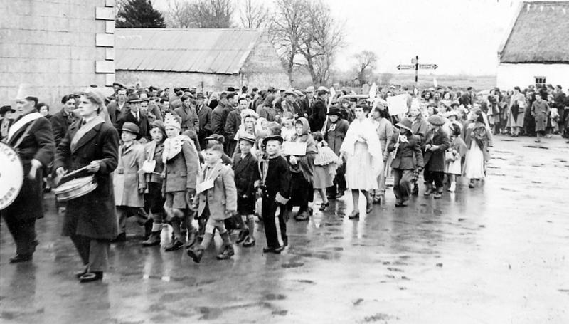 The scene in the village on the final day of the An Tostal festival when the celebrations were brought to a close with a parade, cross-roads dancing and ceremonial lowering of the Tostal flag. An Tostal was a series of festivals throughout the country celebrating Irish life, inaugurated in 1953 and continuing for the next five years.