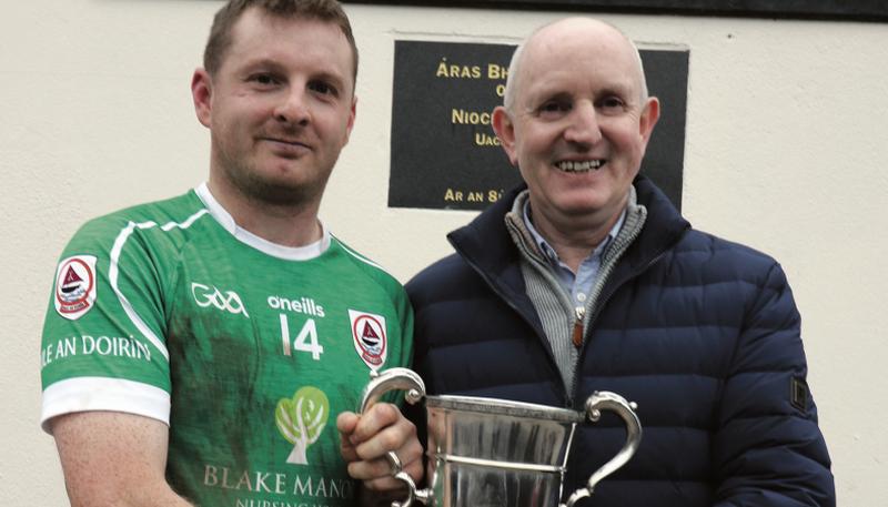 Ballinderreen captain Colm Gill accepts the Junior B Cup from Michael Larkin, Chairman Galway Hurling Committee.