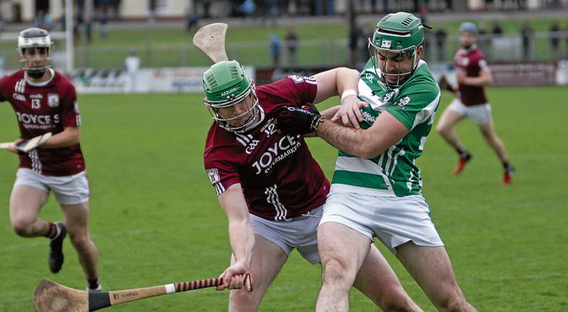 Tom Flynn of Athenry and Killimordaly’s Paul Concannon in action in Kenny Park on Sunday. Photos: David Cunniffe.